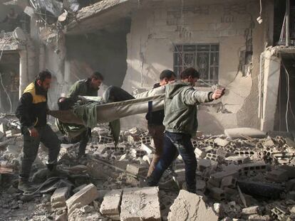 Fuerzas civiles retiran a una víctima de un ataque del Gobierno de El Asad a fuerzas rebeldes en una población próxima a Damasco.