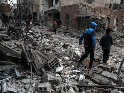 Vecinos inspeccionan los edificios en ruinas tras los bombardeos de la semana pasada en Guta (Siria).