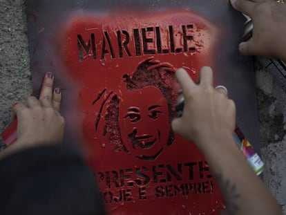 Un grupo de manifestantes pintan con spray una imagen de Marielle Franco con el mensaje: Presente hoy y siempre.