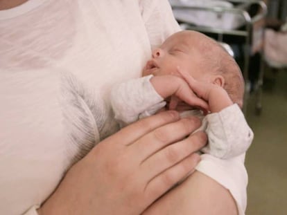 Rocío Tarrida, madre de trillizos, sostiene a uno sus hijos en la unidad de Neonatología del Hospital 12 de Octubre.