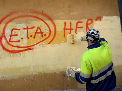 Un trabajador municipal borra una pintada de ETA. Vídeo: comunicado en el que ETA anuncia su disolución.