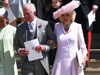 El príncipe Carlos de Inglaterra sale de la capilla de San Jorge del brazo de Doria Ragland, madre de su nuera Meghan, y de su esposa Camila de Cornualles.