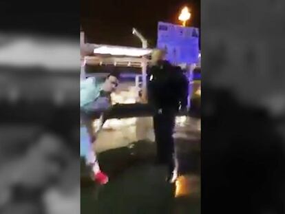 Fotograma del momento en el que el agente de policía asesta un porrazo en la pierna a uno de los jóvenes.