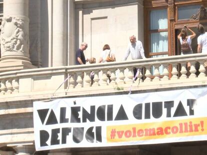 Pancarta de Valencia como ciudad de acogida de refugiados en el Ayuntamiento. En vídeo: Declaraciones de Mónica Oltra.