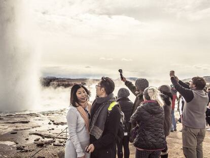 Unos turistas realizan fotos justo en el momento que erupciona el géiser Strokkur.