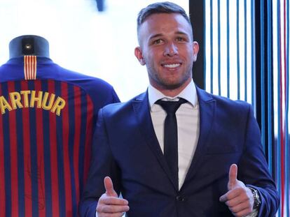 Arthur posa en el Camp Nou junto a la camiseta del Barça.