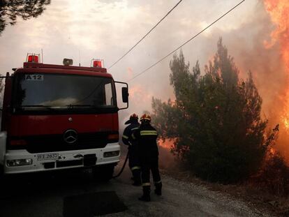 Los bomeros tratan de extinguir un incendio en Penteli, al norte de Atenas (Grecia), este lunes.