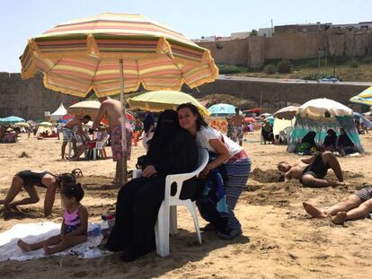 La feminista marroquí Betty Lachgar, este viernes en la playa de Los Udaya, en Rabat, junto a Hanan, sentada y con niqab. En vídeo, declaraciones de Betty Lachgar.