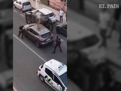 Un hombre huye de la policía saltando por encima de los vehículos aparcados.