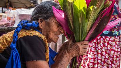 Una mujer se esconde tras un ramo de flores en Juchitán.