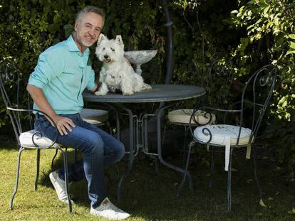 El actor Carlos Hipólito, junto a su perra Trudi en el jardín de su casa, en Madrid.