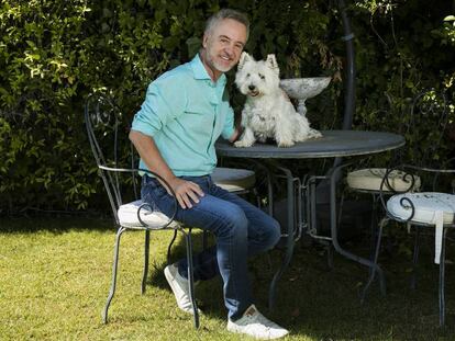 El actor Carlos Hipólito, junto a su perra Trudi en el jardín de su casa, en Madrid.