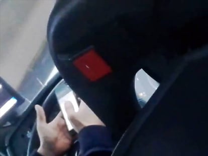 Un conductor fent servir el mòbil al volant.