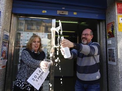 El venedor de l'administració de la plaça Major de Sabadell mostra el tercer premi que ha venut.