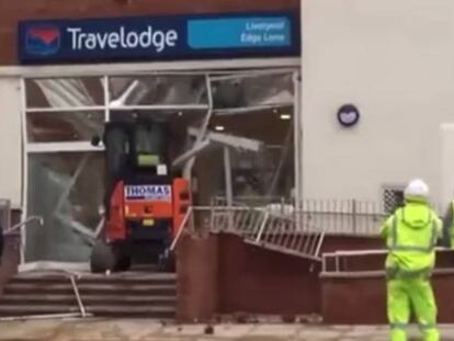 Obrero destrozando la entrada del hotel Travelodge.