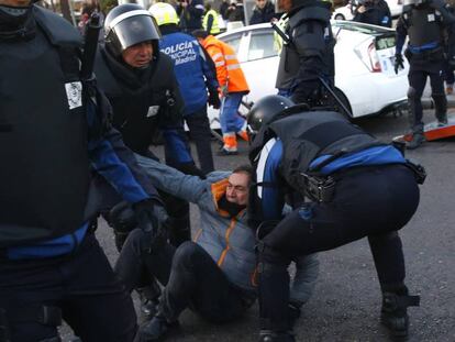 FOTO: Uno de los manifestantes es retirado por los antidisturbios. / VÍDEO: Fragmento de la retransmisión en directo.