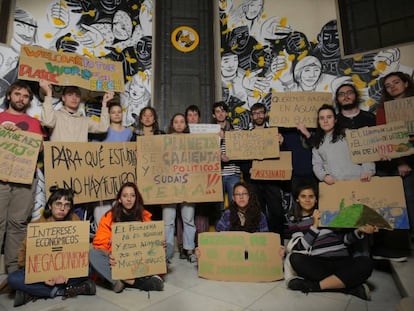 Un grupo de jóvenes en el CS La Ingobernable (Madrid) junto a los carteles con los que irán a la huelga climática del 15M.