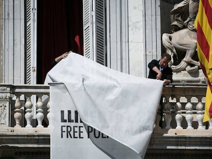 A banner in support of jailed separatist leaders is removed from Catalan government HQ.