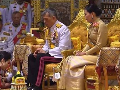 El rey Maha Vajiralongkorn de Tailandia, sentado junto a su esposa, durante la ceremonia para investir a su concubina.