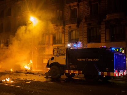 Un camión de agua de los Mossos limpia las barricadas que han ardido durante las protestas de la noche del viernes en Barcelona. En vídeo, las imágenes de la quinta noche de protestas en Cataluña.