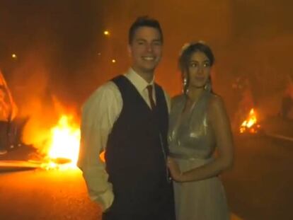 Los novios posan frente a una barricada. En vídeo, los manifestantes vitorean a la pareja.