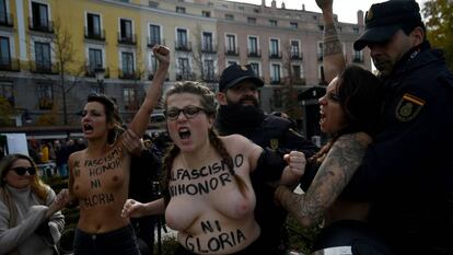 Dos agentes intentan frenar la protesta de las integrantes de Femen en Madrid.
