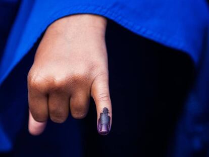 En la imagen, una niña muestra su dedo lleno de tinta, lo que demuestra que la han vacunado contra la polio.