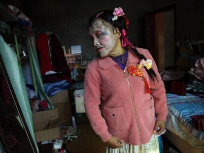 En la imagen, Liu Peilin se prueba un abrigo frente al espejo en su casa de Guanzhong, en China.
