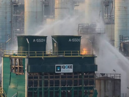 Firefighters work to put out the blaze at the chemical plant (Spanish text).