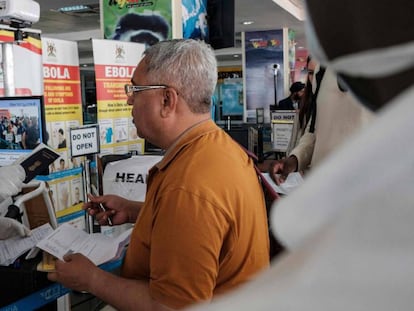 Una trabajadora sanitaria del aeropuerto de Entebbe, en Uganda, comprueba los documentos de un viajero que acaba de llegar al país. En vídeo, declaraciones del presidente de Sudáfrica, Cyril Ramaphosa.