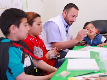 VÍDEO: Un día en el centro de talasemia de Zahle. FOTO: Bouchra, de rojo, y otros dos niños con talasemia juegan en el centro de tratamiento de MSF con uno de sus doctores.