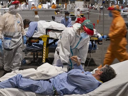 Profesionales sanitarios atienden a pacientes en el pabellón 5 de Ifema, habilitado como hospital de campaña, en Madrid.