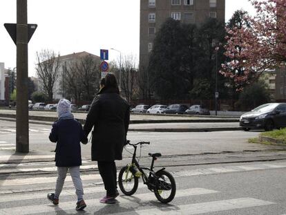 Una madre va con su hijo por la calle en Milán. En vídeo, polémica por algunas de las medidas adoptadas por el Gobierno.