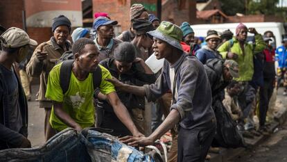 Personas sin hogar reciben cestas de comida de donantes privados durante la cuarentena por Covid-19 en Johanesburgo, Sudáfrica, el 13 de abril de 2020. En vídeo, las consecuencias para África de la congelación de fondos de EE UU para la OMS.