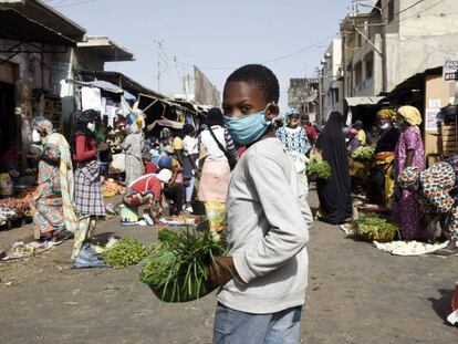 Vídeo: El uso obligatorio de máscaras impulsa el sector textil en Camerún. Foto: Un joven vendedor de verduras usa una máscara facial en Dakar (Senegal) el 20 de abril de 2020, después de que el Ministerio del Interior anunciara el uso obligatorio de las mismas.