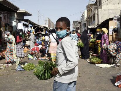 Vídeo: El uso obligatorio de máscaras impulsa el sector textil en Camerún. Foto: Un joven vendedor de verduras usa una máscara facial en Dakar (Senegal) el 20 de abril de 2020, después de que el Ministerio del Interior anunciara el uso obligatorio de las mismas.