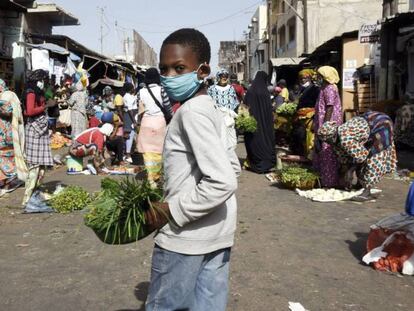 Vídeo: Senegal impone el uso de mascarillas en espacios públicos, por AFP. Foto: Un niño con mascarilla vende verduras en Dakar el 20 de abril, después de que el ministro de Interior anunciara la obligatoriedad de llevar estas prendas protectoras. Seyllou / AFP
