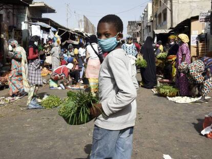 Vídeo: Senegal impone el uso de mascarillas en espacios públicos, por AFP. Foto: Un niño con mascarilla vende verduras en Dakar el 20 de abril, después de que el ministro de Interior anunciara la obligatoriedad de llevar estas prendas protectoras. Seyllou / AFP