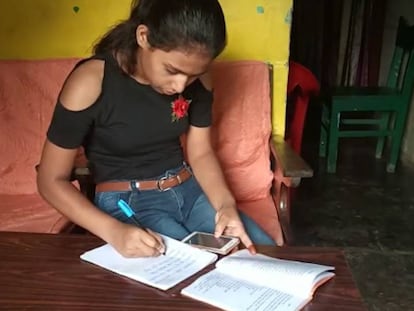 Bijita, una joven de 15 años, de India, recibe a través de su móvil las lecciones para poder seguir estudiando a distancia.