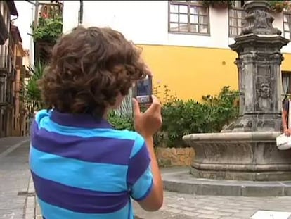 Un niño hace una foto a una pareja de turistas en uno de los lugares en los que se rodó 'Ocho apellidos vascos'.