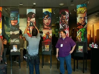 Un fan haciendo una foto a imágenes de distintos superhéroes.