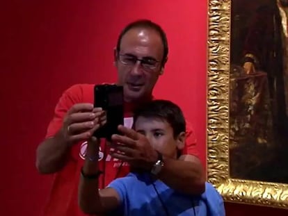 Un hombre y un niño se hacen un selfi en un museo.