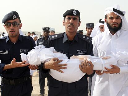 Un funcionario de la defensa civil porta el cuerpo de una de las víctimas durante su funeral.