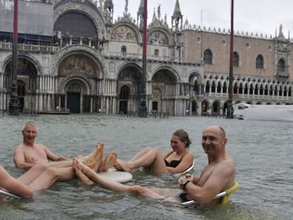 Cuatro turistas bromean en el café de la plaza de San Marcos, en Venecia.