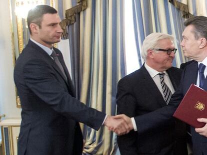 El presidente de Ucrania, Viktor Yanukóvich, da la mano al líder de la oposición Vitaly Klitschko (i).