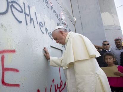 El Papa toca el muro que separa Israel de Cisjordania.