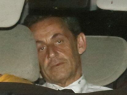 Sarkozy, no caminho da delegacia, diante do juiz que lhe indiciou.