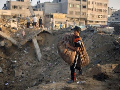 Un chico pasa ante los restos de su casa bombardeada en Gaza.