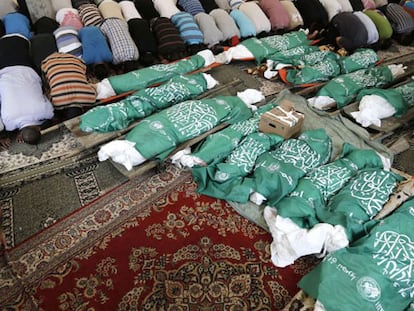 Palestinos rezam no funeral pelos membros de uma família morridos a véspera em Jan Yunis.