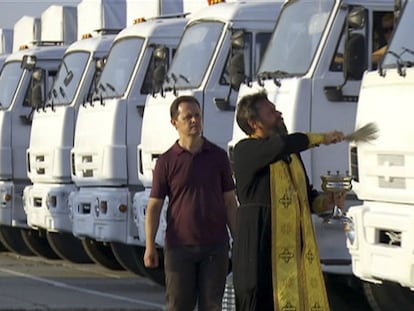 Un miembro del clero de la Iglesia Ortodoxa rusa bendice a los camiones el 12 de agosto en las afueras de Moscú / Foto: AP | Vídeo: Reuters Live!